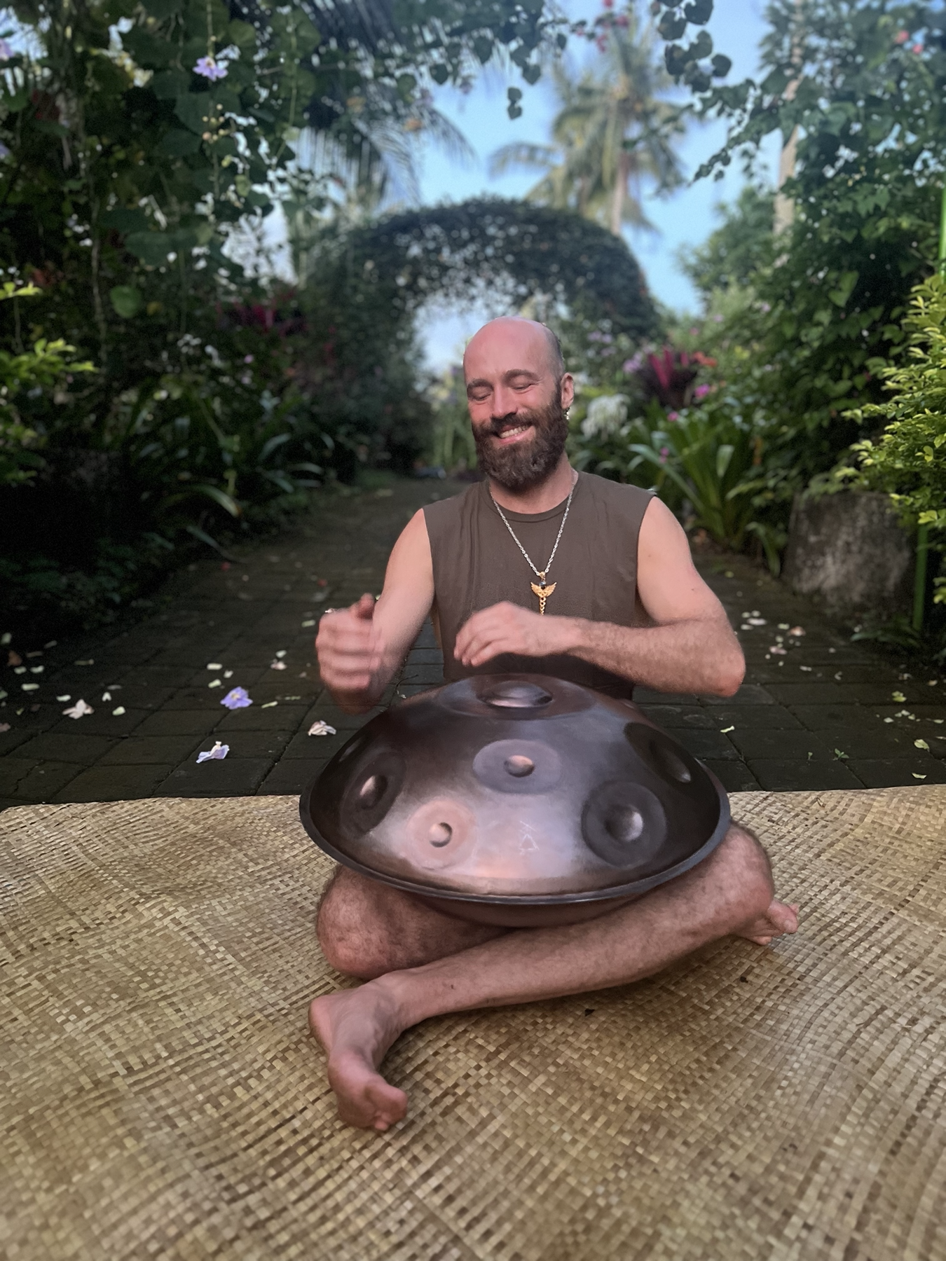 Raphael playing the handpan in the tropical garden