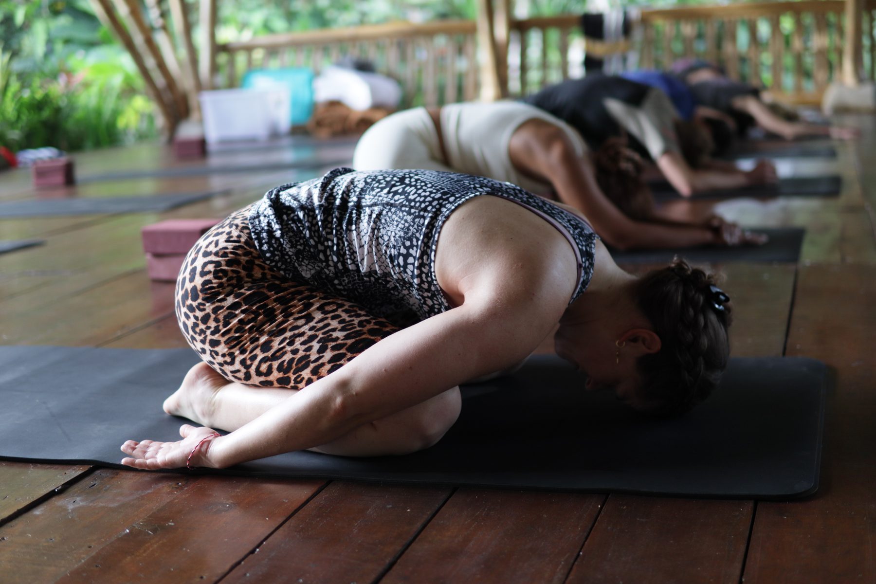 Participants settling into a grounded yoga posture