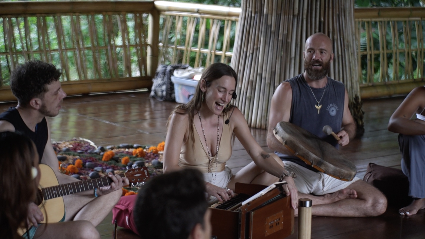 The group singing and making music together in the bamboo shala