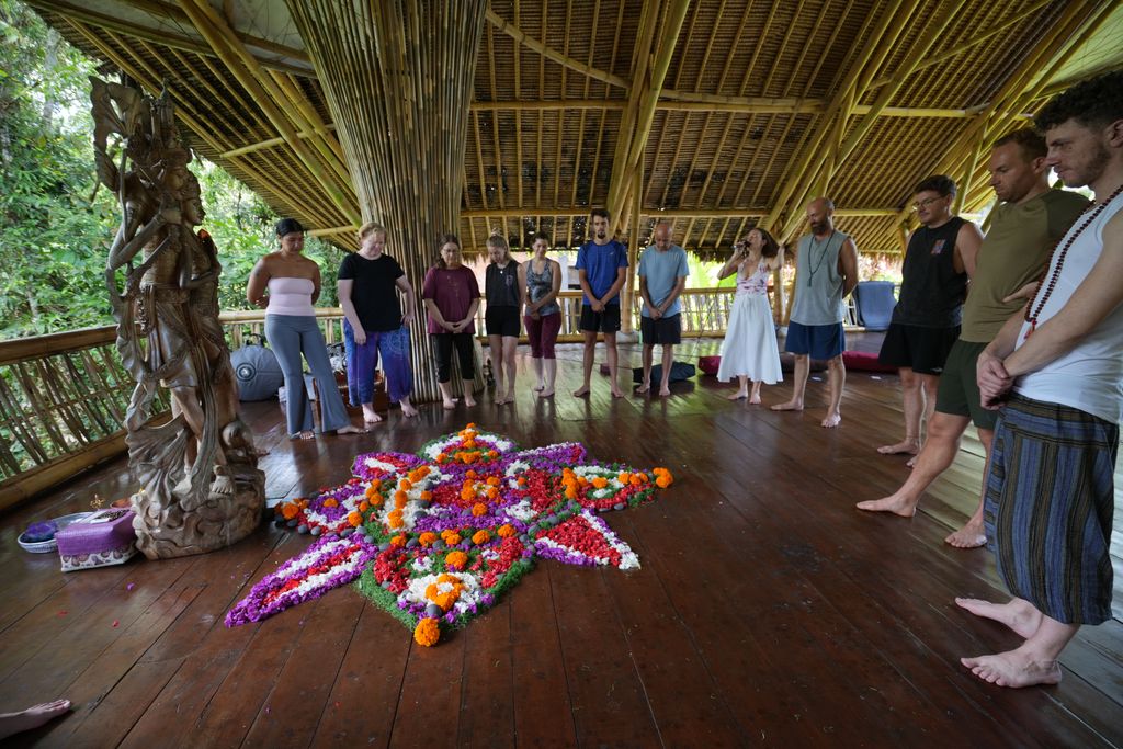 Participants gathered around a flower mandala in ceremony