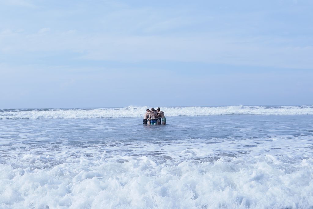 Participants embracing beside the ocean in West Bali